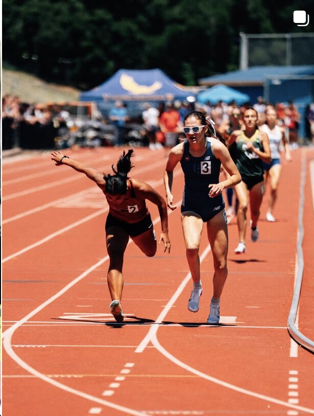 Sprinters battling down the straightaway at a track meet